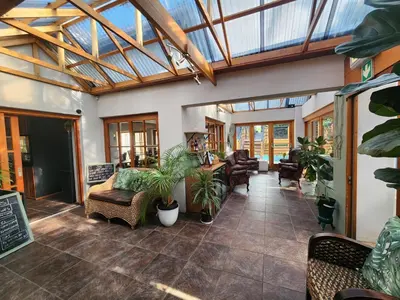 a conservatory with a glass ceiling and plants at Little Scotia in Cape Town