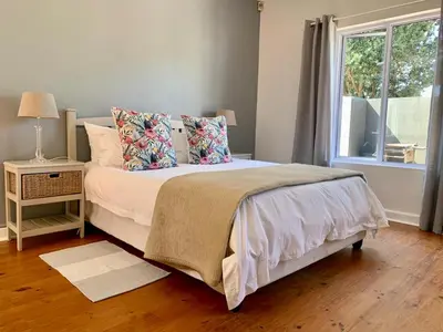 a bedroom with a bed with pillows and a window at Anchor's Rest in Hermanus