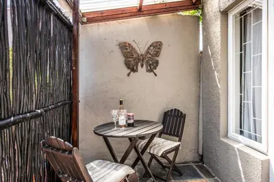 a butterfly on a wall with a table and chairs at Greenlawns B&B in Cape Town