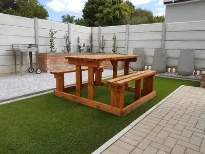 a wooden picnic table and bench on grass at Columbine Place in Durbanville