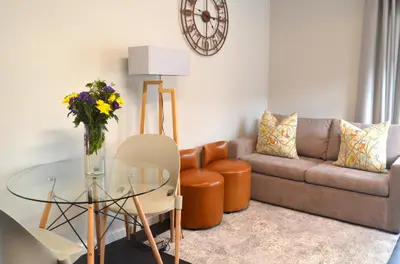 a living room with a couch and a glass table at Columbine Place in Durbanville