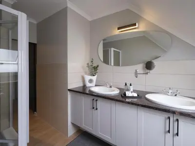 a bathroom with two sinks and a mirror at Sanddrif Stellenbosch Guest Farm in Stellenbosch