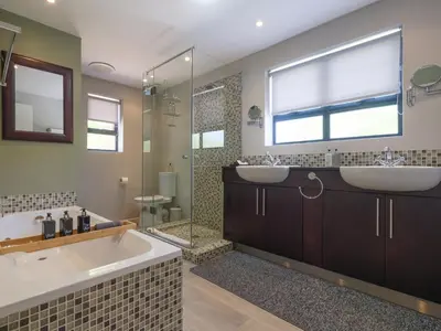 a bathroom with a tub and a sink and a shower at Sanddrif Stellenbosch Guest Farm in Stellenbosch