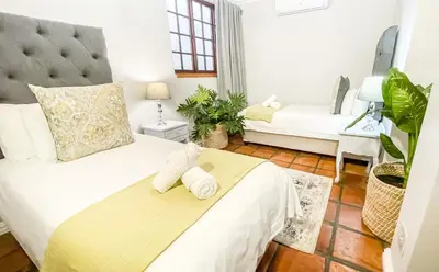 a bedroom with a bed with a stuffed animal on it at Olive Tree Boutique Hotel in Paarl