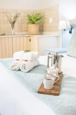 a tray of towels and cups on a bed at Olive Tree Boutique Hotel in Paarl