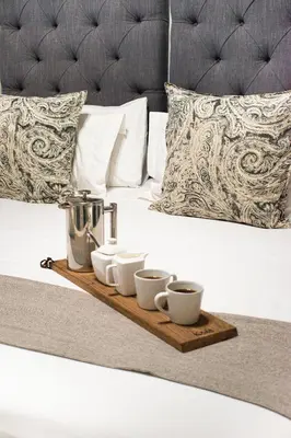 a tray with cups and a juicer on a bed at Olive Tree Boutique Hotel in Paarl