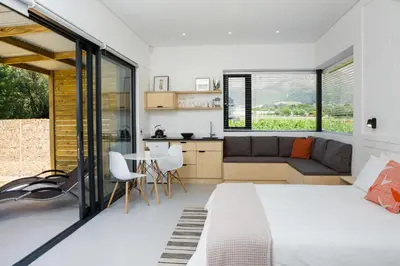 a bedroom with a bed and a couch and a table at Gite in Franschhoek