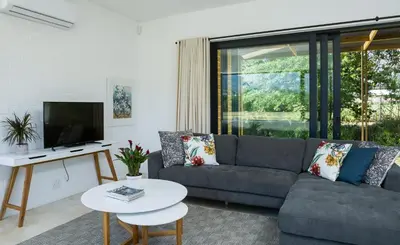 a living room with a couch and a tv at Gite in Franschhoek