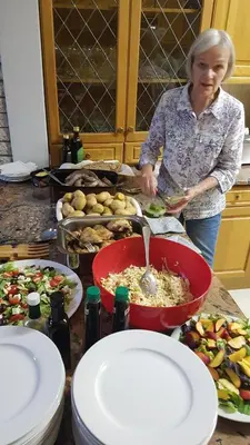 a woman standing in a kitchen preparing food at Besigheim in Stellenbosch
