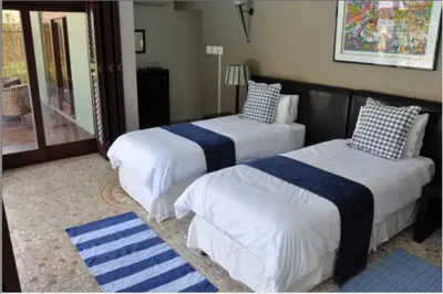 a bedroom with two beds with blue and white sheets at Ridgemor Villa in Somerset West