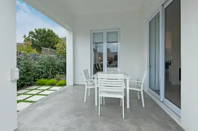 a white dining table and chairs on a patio at Perla in Hermanus
