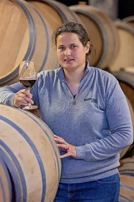 a woman holding a glass of wine in a barrel at Holden Manz Country House in Franschhoek