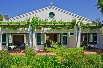 a white house with green ivy on it at Eikendal Lodge in Stellenbosch