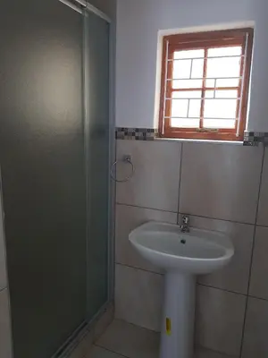 a bathroom with a sink and a glass shower at Fama Lodge Single Rooms in Cape Town