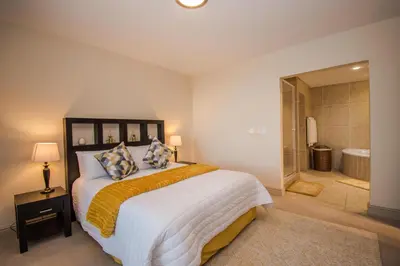 a bedroom with a large bed and a bathroom at Ocean View Luxury Self-Catering in Strand