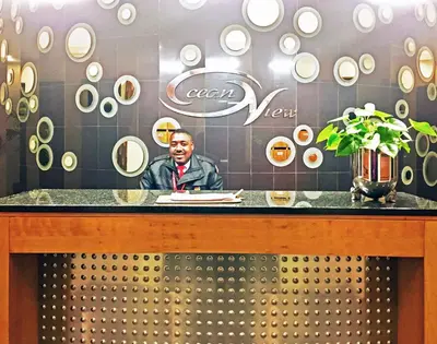 a man sitting at a counter in a restaurant at Ocean View Luxury Self-Catering in Strand