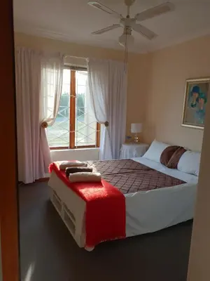 a bedroom with a large bed and a window at 18 Patrys Crescent in Hermanus