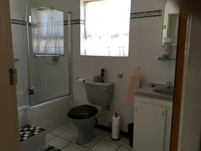 a bathroom with a toilet and a sink and a shower at 18 Patrys Crescent in Hermanus