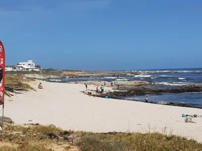 a group of people on a beach near the ocean at 18 Patrys Crescent in Hermanus