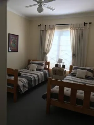 a bedroom with two beds and a window at 18 Patrys Crescent in Hermanus