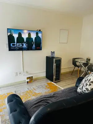 a living room with a couch and a flat screen tv at Modern secure apartment in Strand - Little Greece in Strand