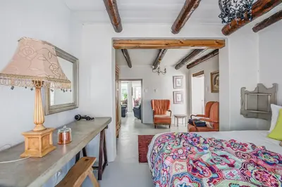 a bedroom with a bed and a table with a lamp at De Kale Kat in Greyton