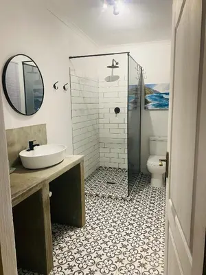 a bathroom with a shower and a sink and a toilet at Winelands guest room in Stellenbosch