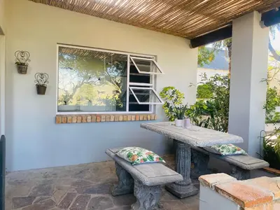 a patio with a table and a window at Winelands guest room in Stellenbosch