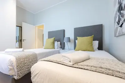 two beds sitting next to each other in a bedroom at Axis Luxury Apartments by Century City Hotels in Cape Town