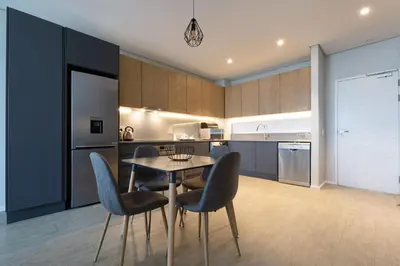 a kitchen with a table and chairs in a room at Axis Luxury Apartments by Century City Hotels in Cape Town