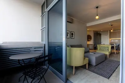 a room with a table and chairs and a living room at Axis Luxury Apartments by Century City Hotels in Cape Town