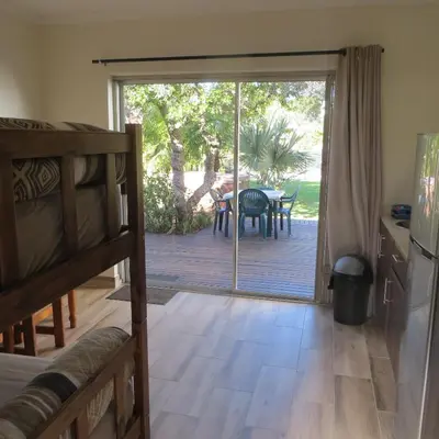 a bedroom with a sliding glass door leading to a deck at Cape Oasis Guesthouse in Bloubergstrand