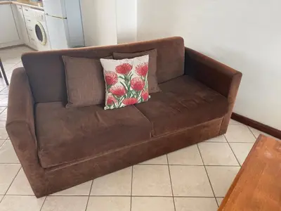a brown couch with two pillows on it in a kitchen at Ocean View B1001, Blouberg in Bloubergstrand