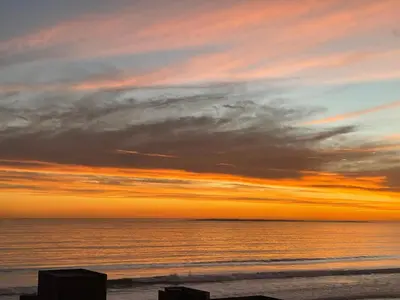 a sunset on a beach with the ocean at Ocean View B1001, Blouberg in Bloubergstrand