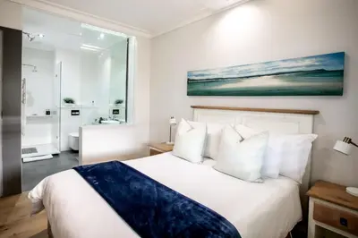 a bedroom with a large white bed with white pillows at Bayview 303 in Hermanus