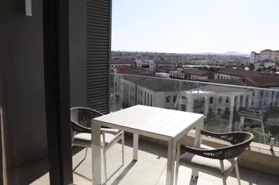 a white table and chairs on a balcony with a view at The Residences at Crystal Towers in Cape Town