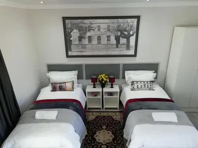 a bedroom with two beds and a picture on the wall at Middelplaas Paarl Guesthouse in Paarl