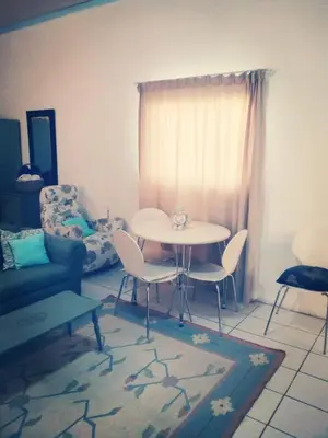 a living room with a table and chairs and a couch at 36 Df Strauss Street in Kleinmond