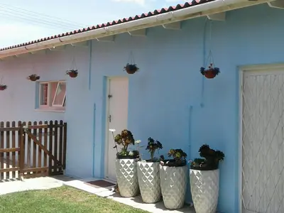 a blue house with four large vases with plants in them at 36 Df Strauss Street in Kleinmond