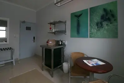 a room with a table and a table and a chair at Zzzone Boutique Hostel in Hermanus