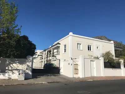 a white house with a gate in front of it at Maison Malherbe in Franschhoek