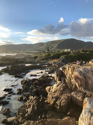 a group of people standing on the rocks near a river at 42 on 4th in Hermanus