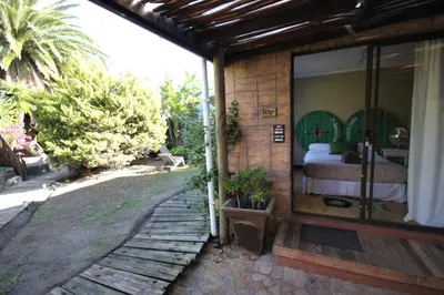 a room with a bed and a glass door at Saltycrax Backpackers and Surf Hostel in Bloubergstrand