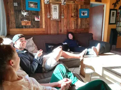 a group of people sitting on a couch at Saltycrax Backpackers and Surf Hostel in Bloubergstrand