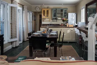 a kitchen and dining room with a table and chairs at Cook's Cottage in Franschhoek