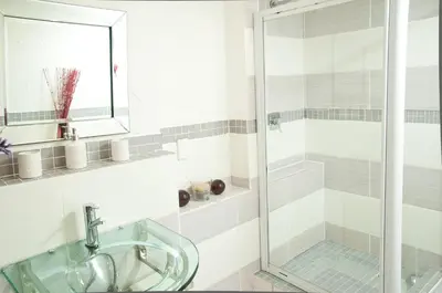 a bathroom with a glass shower and a sink at a Vue Guesthouse in Somerset West