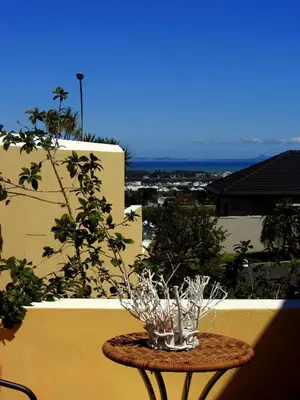 a table with glasses on it on a balcony at a Vue Guesthouse in Somerset West