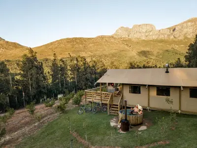 a house with a dog sitting in a bucket in front of it at AfriCamps at Doolhof Wine Estate in Wellington