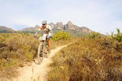 a man riding a bike on a dirt trail at AfriCamps at Doolhof Wine Estate in Wellington