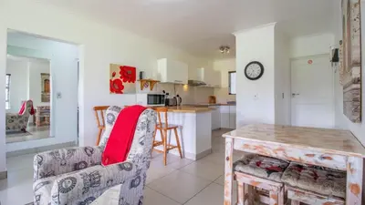 a kitchen and living room with a table and chairs at Greenways Strand Golf Beach C3 in Strand